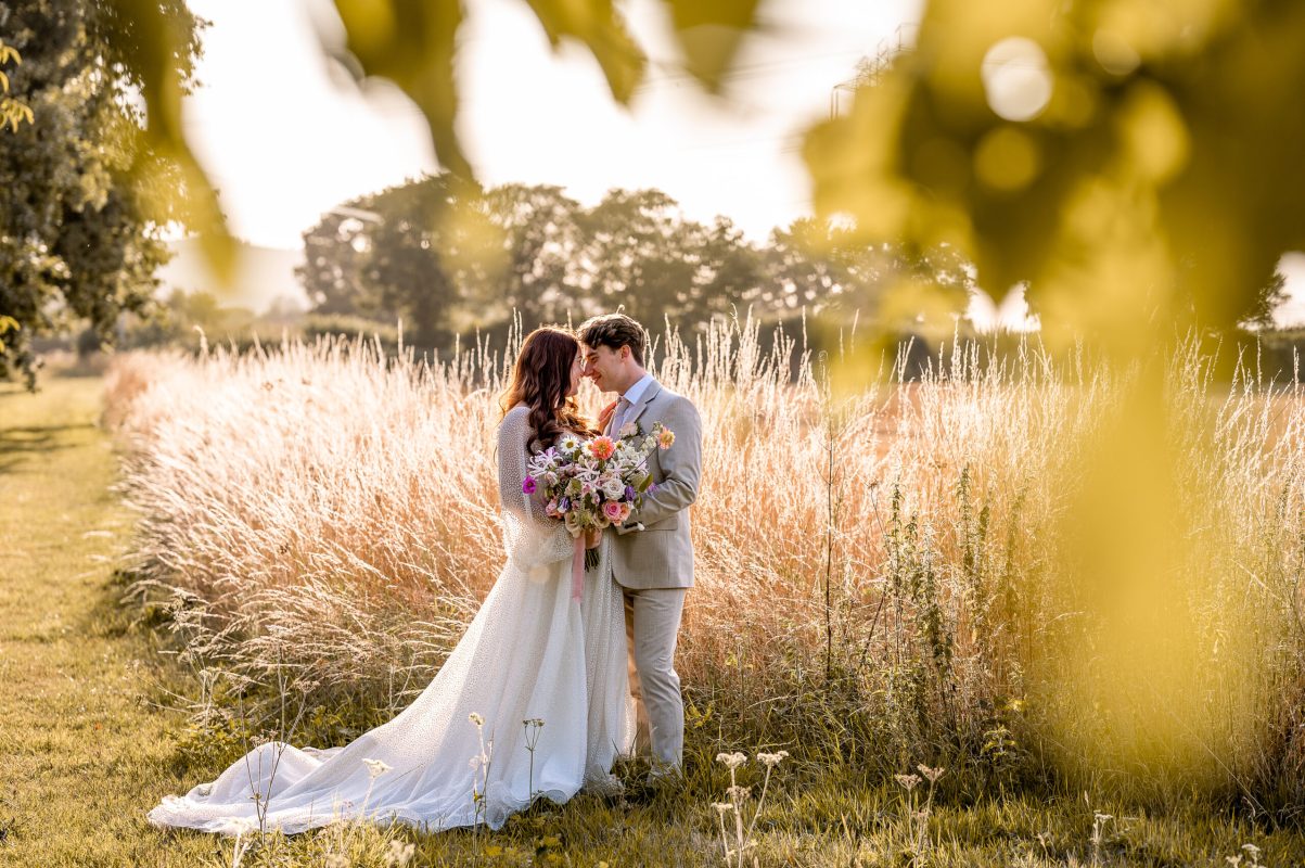 Bride and groom standing with their heads together at the Tithe Barn in Ditcham